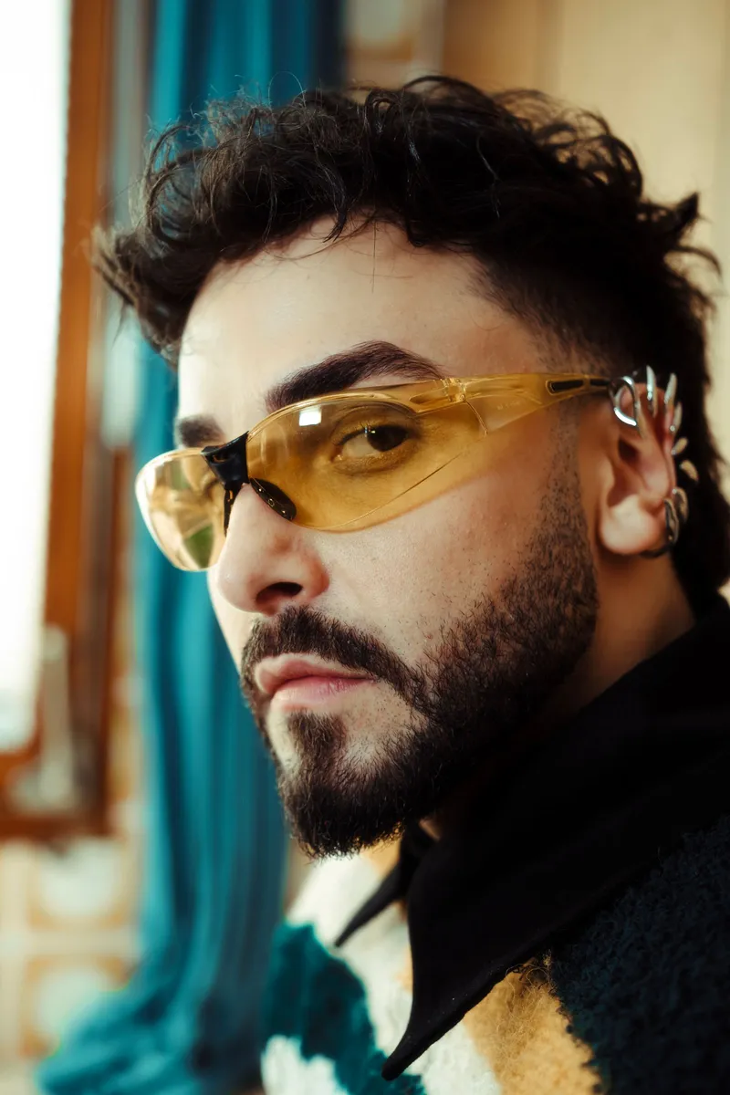 Un hombre con barba luciendo gafas de lente tintada amarilla