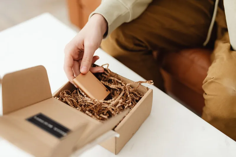Una persona desembalando un artículo de una caja de cartón
