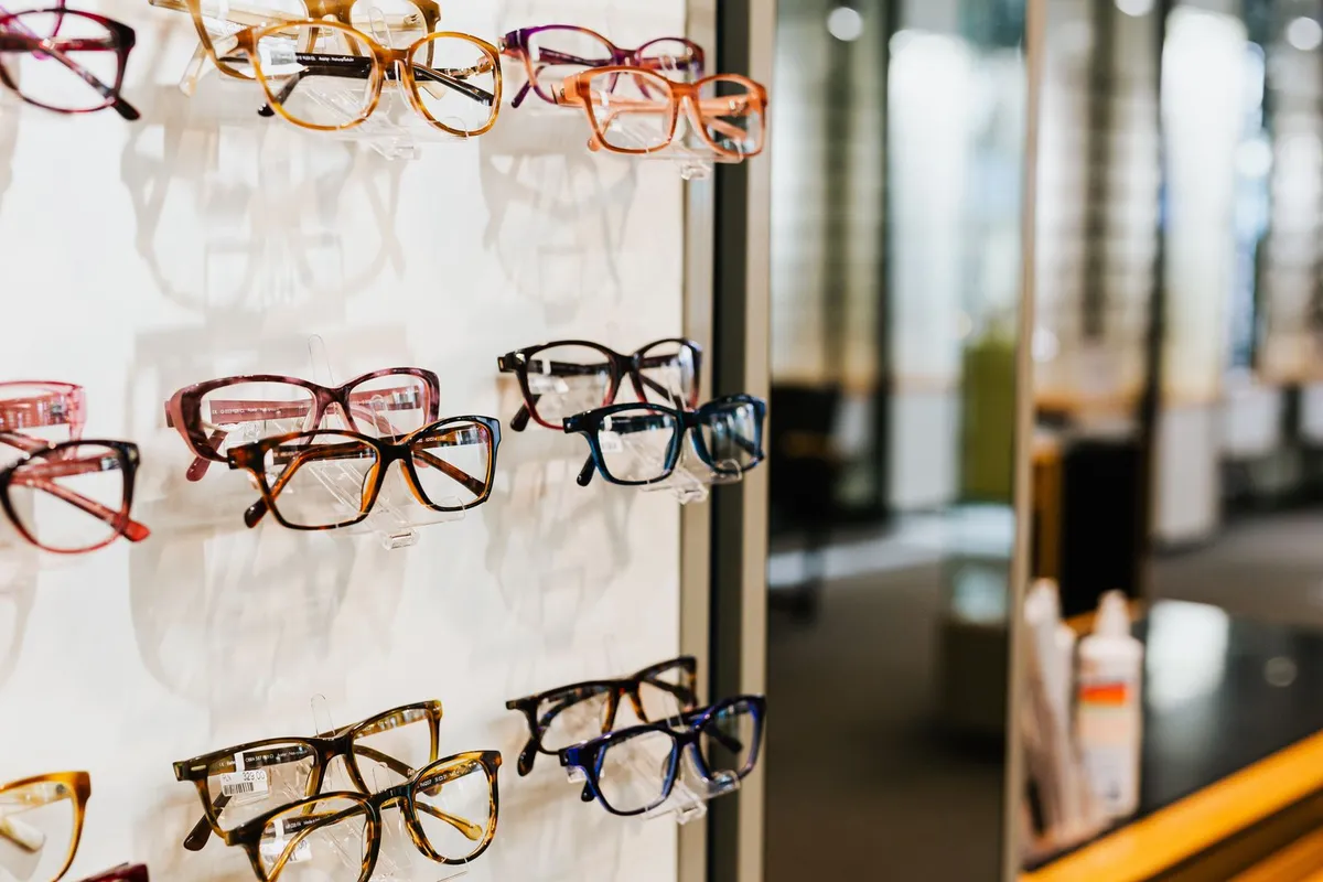 Varias gafas expuestas sobre una estantería de cristal bien iluminada